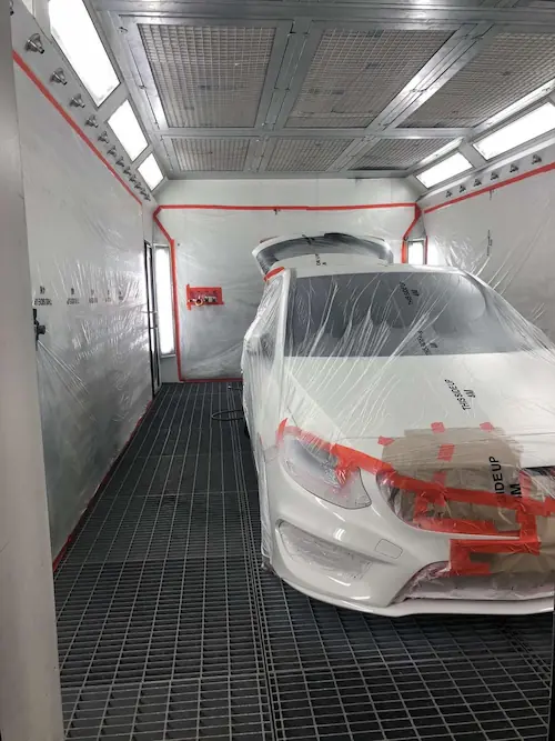Home | Non-Fault Accident Claim & Vehicle Recovery London Car inside professional paint booth undergoing accident repair under SSS Claims UK management.