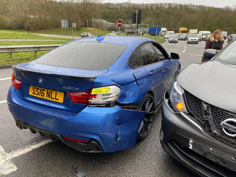 Home | Non-Fault Accident Claim & Vehicle Recovery London Blue BMW and grey car involved in a rear-end collision on a UK road, representing non-fault accident claim handled by SSS Claims London.